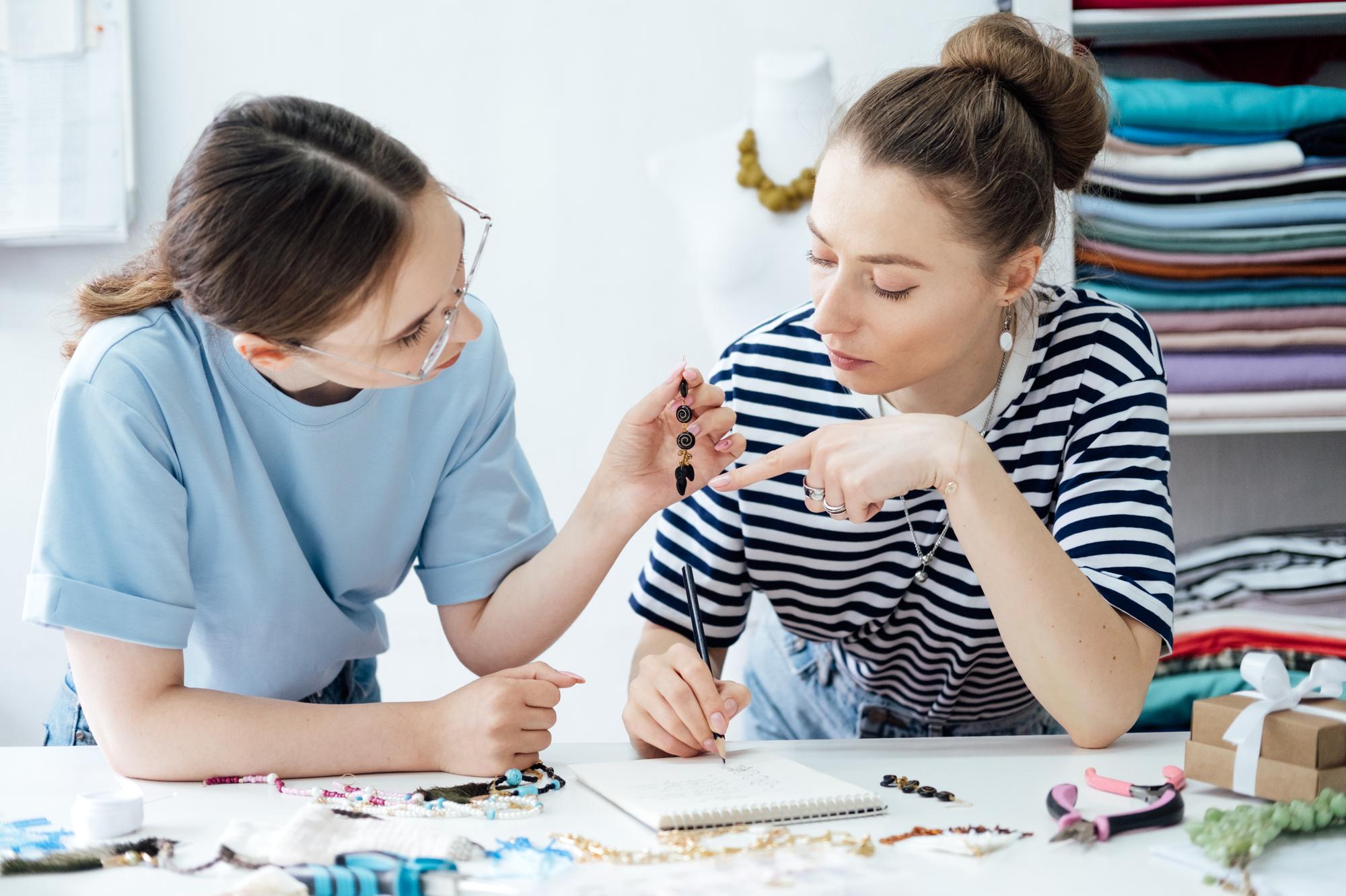 Instructor reviewing embroidered sample with student